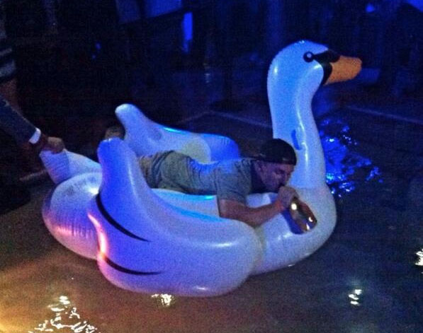 Just Johnny Manziel riding an inflatable swan with a champagne bottle.