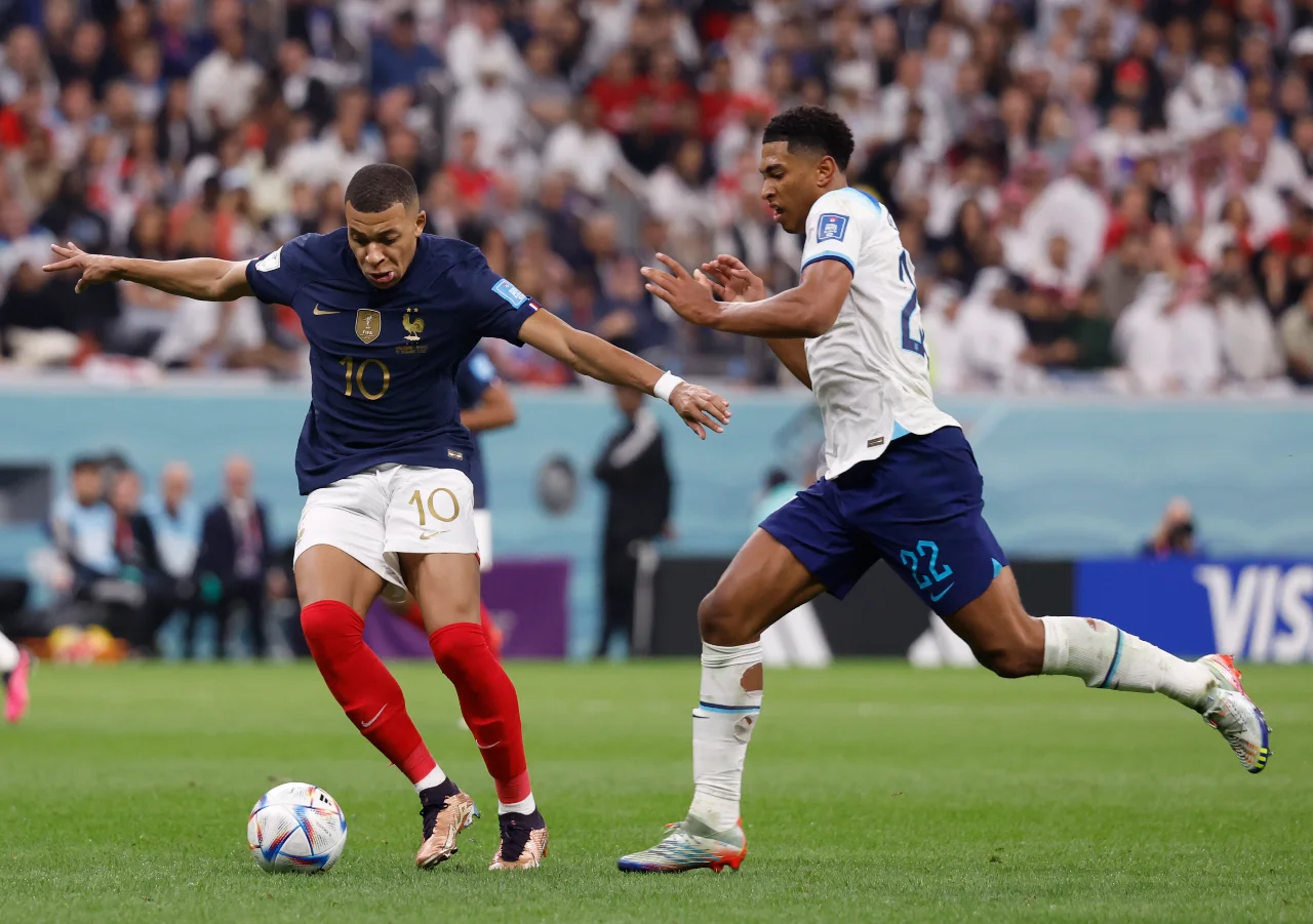 France forward Kylian Mbapp (10) controls the ball in front of England midfielder Jude Bellingham (22) during the second half of a quarterfinal game in the 2022 FIFA World Cup at Al-Bayt Stadium.