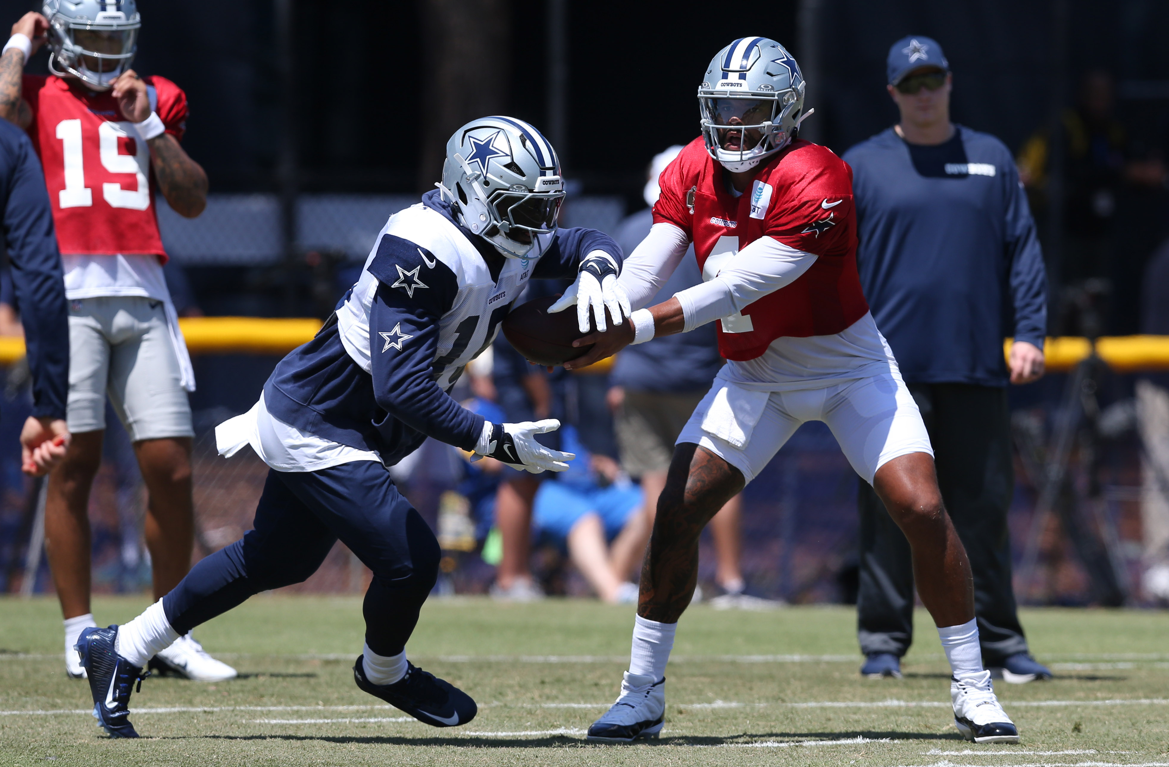 Dallas Cowboys quarterback Dak Prescott (4) hands off to running back Ezekiel Elliott (15) during training camp at the River Ridge Playing Fields in Oxnard, California.