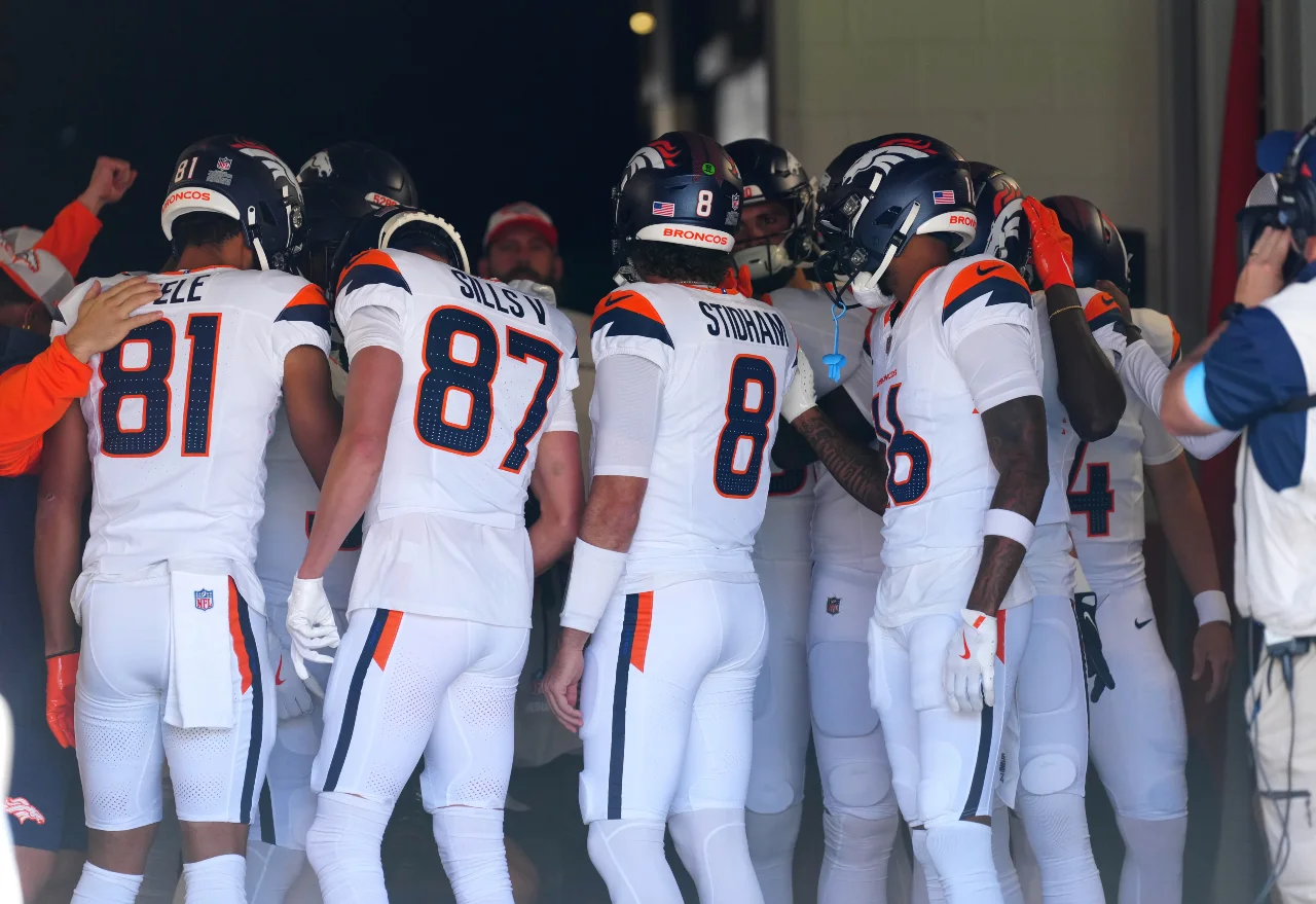 Members of the Denver Broncos offense huddle before the game against the Arizona Cardinals at Empower Field at Mile High.