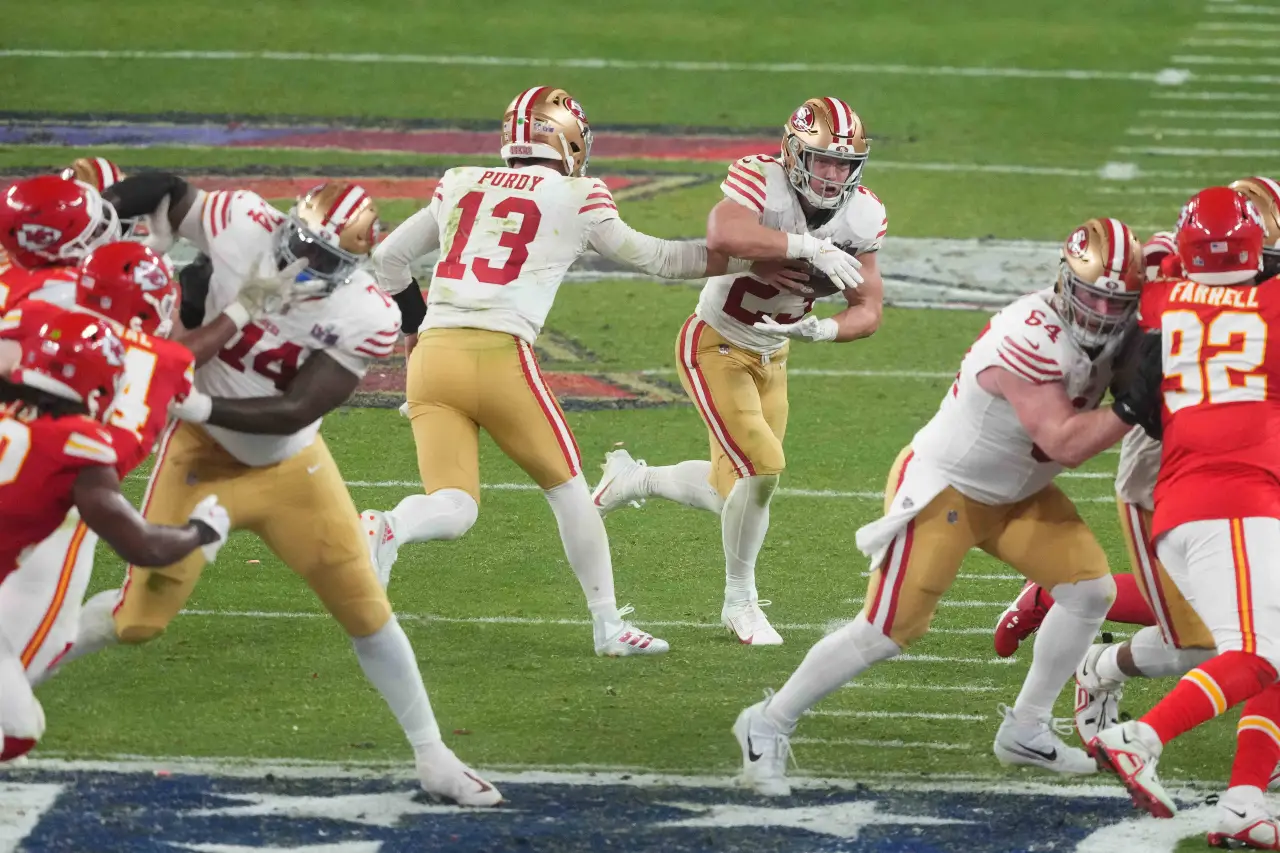 San Francisco 49ers quarterback Brock Purdy (13) hands the ball to running back Christian McCaffrey (23) against the Kansas City Chiefs during overtime of Super Bowl LVIII at Allegiant Stadium.