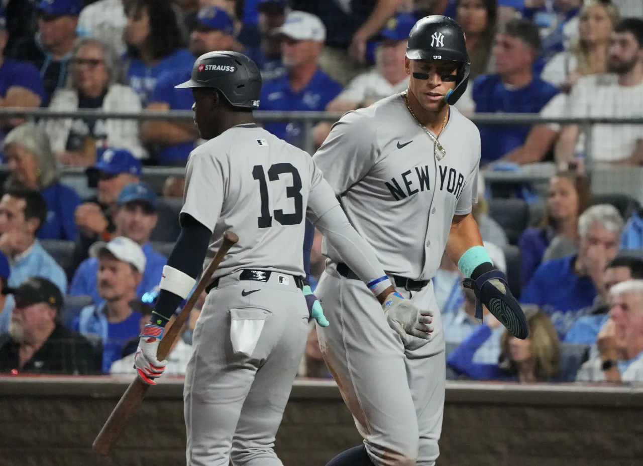 New York Yankees outfielder Aaron Judge (99) celebrates with third baseman Jazz Chisholm Jr. (13) after scoring during the sixth inning against the Kansas City Royals during game four of the ALDS for the 2024 MLB Playoffs at Kauffman Stadium.