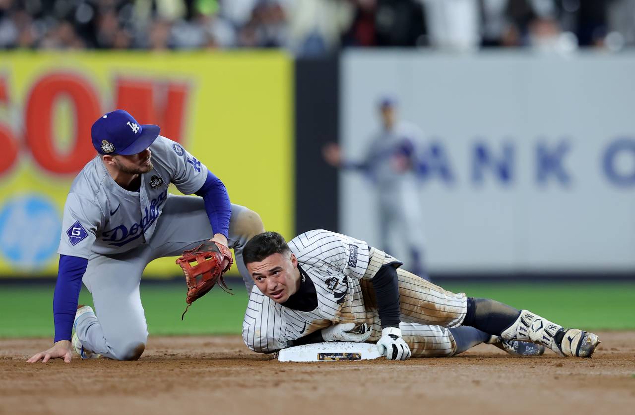 New York Yankees shortstop Anthony Volpe (11) slides safely into second with a double against Los Angeles Dodgers second baseman Gavin Lux (9) during the eighth inning in game four of the 2024 MLB World Series at Yankee Stadium.