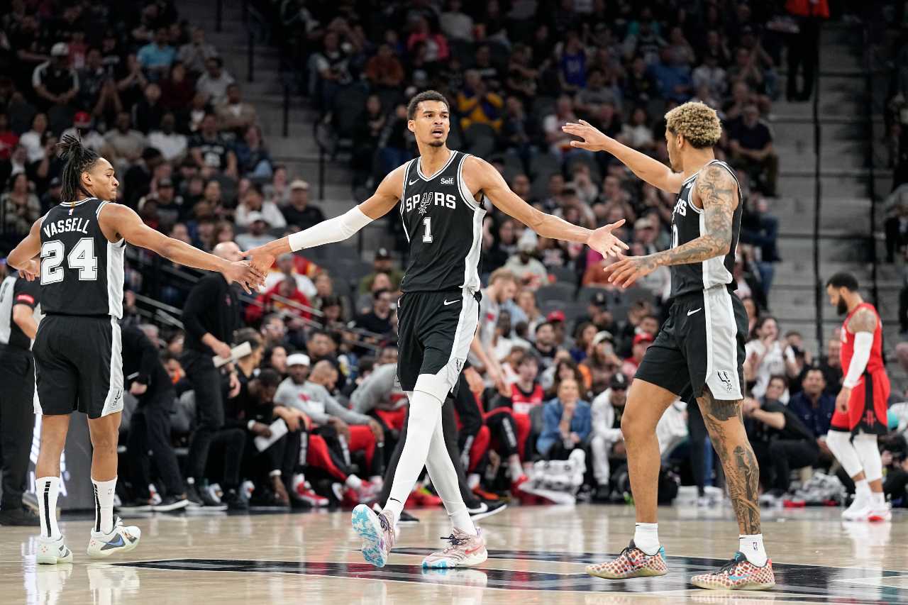 San Antonio Spurs forward Victor Wembanyama (1) reacts with guard Devin Vassell (24) and forward Jeremy Sochan (10) before a time out during the first half against the Houston Rockets